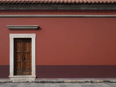 A photorealistic image of a red wall with a wooden door and stone accents.