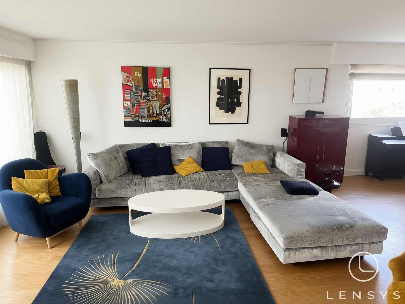 A modern living room with a gray sectional sofa, blue armchair, and artwork.